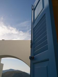 una puerta azul con vistas a las montañas en Kyma sto Phos en Chora Folegandros