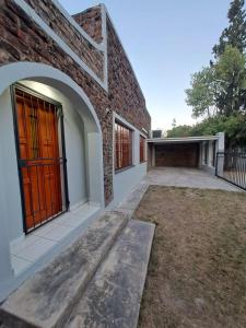 a brick building with a red door and a yard at 2 On Greeff in Graaff-Reinet