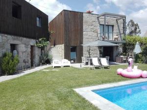 een huis met een zwembad in de tuin bij Casas da Li in Arcos de Valdevez