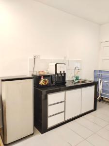 a kitchen with a counter with a sink and a microwave at Sakura 1 Homestay Kampar Landed in Kampar