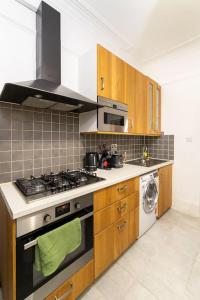 a kitchen with a stove and a washing machine at (Covent Garden) Cozy Apartment Central London in London