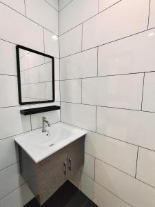 a white bathroom with a sink and a mirror at Sakura 1 Homestay Kampar Landed in Kampar