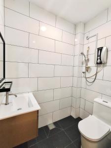 a white bathroom with a toilet and a sink at Sakura 1 Homestay Kampar Landed in Kampar
