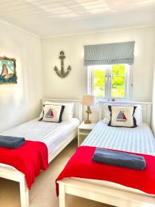 a bedroom with two beds and a window at Spinnaker Lodge · Cotswolds Lakeside Home in South Cerney