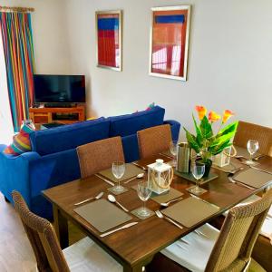 een woonkamer met een tafel en een blauwe bank bij Spinnaker Lodge · Cotswolds Lakeside Home in South Cerney
