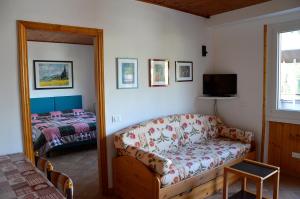 a living room with a couch and a bed at Appartamenti Vacanze Casa Marilleva in Mezzana