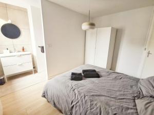 ein Schlafzimmer mit einem Bett mit zwei schwarzen Kissen darauf in der Unterkunft Le Contemporain (Centre - Gare - Commerces) in Lens