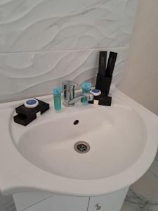 a white bathroom sink with complimentary cosmetics at CASA SONIA in Târgu Jiu