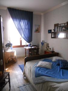 ein Schlafzimmer mit einem blauen Bett und einem Fenster in der Unterkunft Chambres D'Hôtes Des 3 Rois in Verdun-sur-Meuse
