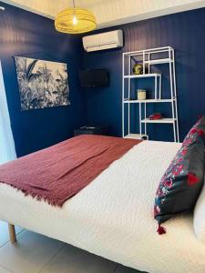 ein Schlafzimmer mit einem großen Bett mit einer blauen Wand in der Unterkunft Le Spicy 2 minutes centre historique parking in Sarlat-la-Canéda