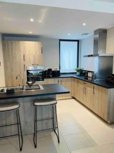 eine Küche mit einem Waschbecken und 2 Barhockern in der Unterkunft Le Spicy 2 minutes centre historique parking in Sarlat-la-Canéda + 5 Fotos