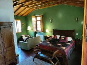 1 dormitorio con paredes verdes, 1 cama y 1 silla en Quinta Padre Lobo en Santa Maria da Feira