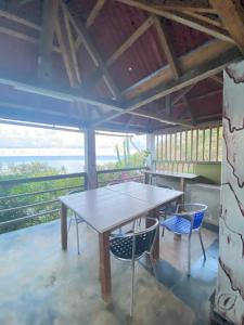 a table and chairs in a room with a view of the ocean at La Rosedepine chez Mariani chez l'habitant in Rodrigues Island