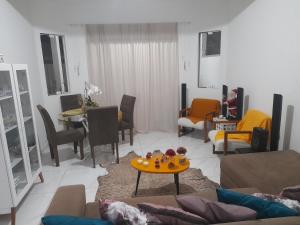 a living room with couches and chairs and a table at Casa ampla e aconchegante in Florianópolis