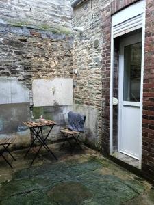 a table and chairs next to a building with a door at Maison de ville quartier Pasteur in Cherbourg en Cotentin