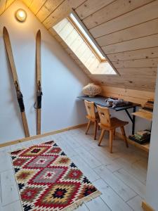 a attic room with a table and skis on the wall at Domki Szczyt Beztroski - Sauna, Jacuzzi in Nowy Targ