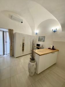 a large white kitchen with a counter and a vase at Casa Tua - Sea View Chianca in Vieste