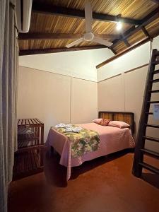 1 dormitorio con 1 cama y ventilador de techo en Cabinas Tropicales, en Puerto Jiménez