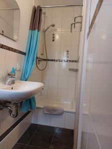 een badkamer met een wastafel en een douche bij Gästehaus Walter in Hardt