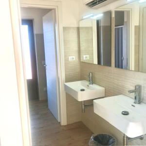 a bathroom with two sinks and a mirror at Agricampeggio Verde Etna in Aci SantʼAntonio
