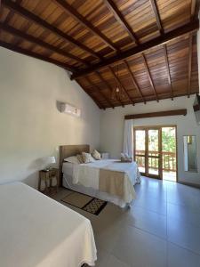 a bedroom with two beds and a wooden ceiling at La Bella Suítes in Ilhabela