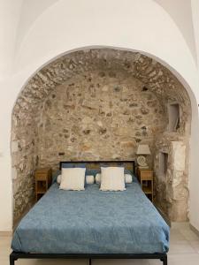 a bedroom with a stone wall with a bed at Casa Tua - Sea View Chianca in Vieste