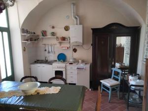 a kitchen with a table and a table and a kitchen with a tableablish at Casa Nana' in Carpignano Sesia +2 photos