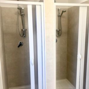 una doccia in un bagno con una porta in vetro di Agricampeggio Verde Etna ad Aci SantʼAntonio Altre 37 foto