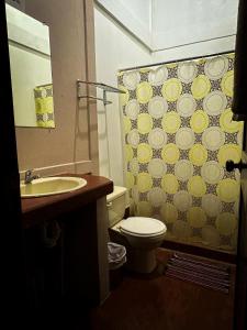 a bathroom with a toilet and a shower curtain at Cabinas Tropicales in Puerto Jiménez