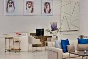 a living room with white furniture and portraits on the wall at Hilton Dubai Palm Jumeirah in Dubai