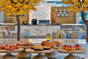 a table with different types of pastries and cakes on plates at Hilton Dubai Palm Jumeirah in Dubai