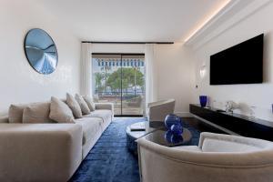 a living room with a couch and a tv at Palais Des Iles - La Croisette in Cannes
