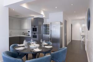 a kitchen with a table and blue chairs in a room at Palais Des Iles - La Croisette in Cannes