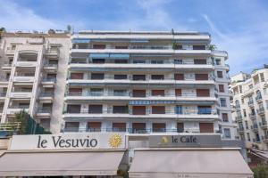 - un grand bâtiment blanc avec un panneau devant dans l'établissement Palais Des Iles - La Croisette, à Cannes