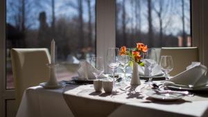 stół z białą tkaniną stołową z okularami i kwiatami w obiekcie Lotus Therme Hotel & Spa w Hévízie