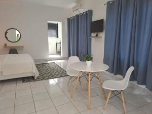 a room with a table and chairs and a bed at 2 On Greeff in Graaff-Reinet