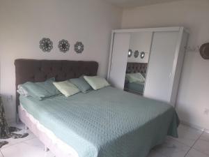 a bedroom with a large bed and a mirror at Casa ampla e aconchegante in Florianópolis