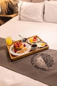 ein Tablett mit Frühstücksspeisen auf einem Bett in der Unterkunft Mándala Hotel Belén in Medellín
