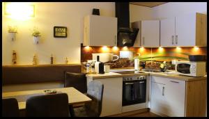 a kitchen with white cabinets and a table with a microwave at Apartment Tirol in Kundl