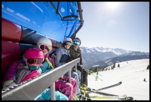Apartment Tirol في كوندلي: مجموعة من الناس يجلسون على مصعد التزلج
