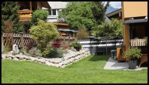 un patio con una valla de piedra y un jardín en Apartment Tirol, en Kundl