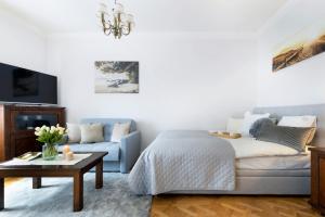 a living room with a bed and a couch at Elite Apartments Hamptons Old Town in Gdańsk
