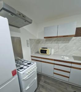 a small kitchen with a stove and a microwave at Classic Studio near Headingley Stadium in Headingley