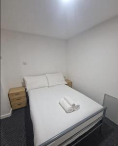 a white bed with a pair of shoes on it at Classic Studio near Headingley Stadium in Headingley
