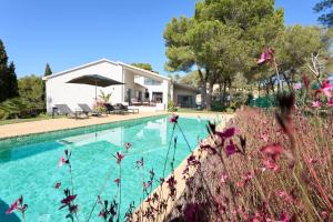 a swimming pool with a house and some flowers at Casa Brisa Boutique Guest House - Gay Men Only in Sant Pere de Ribes