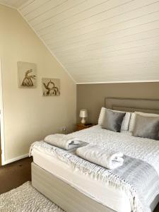 a bedroom with a large bed with white sheets at Grange Lodge in South Cerney