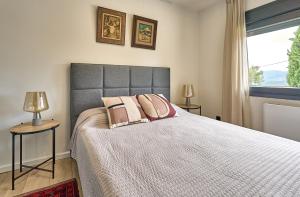 a bedroom with a bed with two lamps and a window at Casa Brisa Boutique Guest House - Gay Men Only in Sant Pere de Ribes