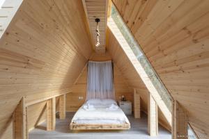 Pokój z łóżkiem na drewnianym poddaszu w obiekcie Hill Wonder w mieście Batumi