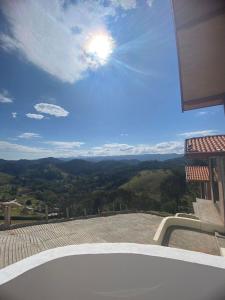 Cette maison dispose d'un balcon offrant une vue sur les montagnes. dans l'établissement Chalé Estância da Pinha seu Refúgio na Montanha, à Santo Antônio do Pinhal
