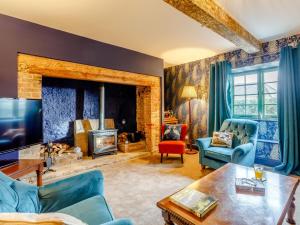 a living room with blue furniture and a fireplace at 6 Bed in Blandford Forum 80549 in Milborne Saint Andrew